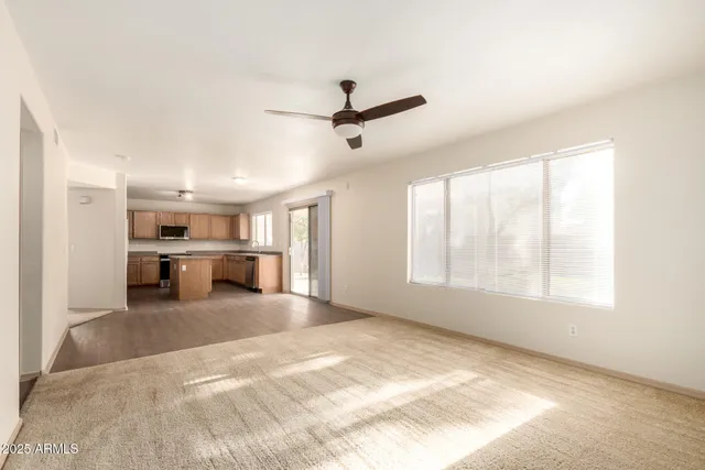 a view of a livingroom with a ceiling fan and window