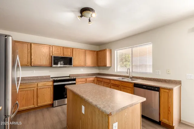 a kitchen with stainless steel appliances granite countertop a sink and a stove