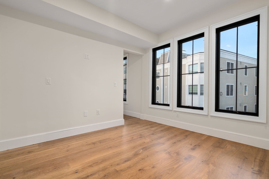 34 Vinton Street, Unit 3 Boston, MA 02127 - Photo 13 of 29 an empty room with wooden floor and windows