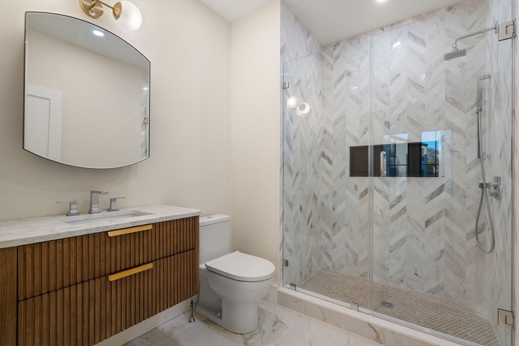 34 Vinton Street, Unit 3 Boston, MA 02127 - Photo 15 of 29 a bathroom with a granite countertop sink a toilet and a mirror