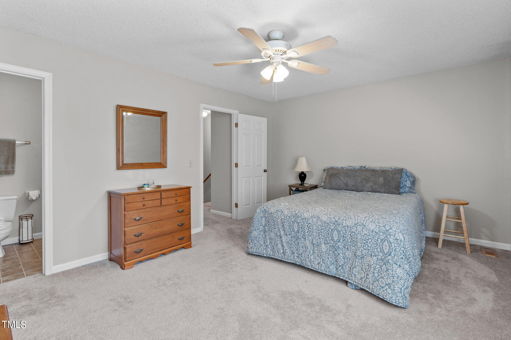 6908 Saxby Court Raleigh, NC 27613 - Photo 22 of 27 a bedroom with a bed and a chandelier