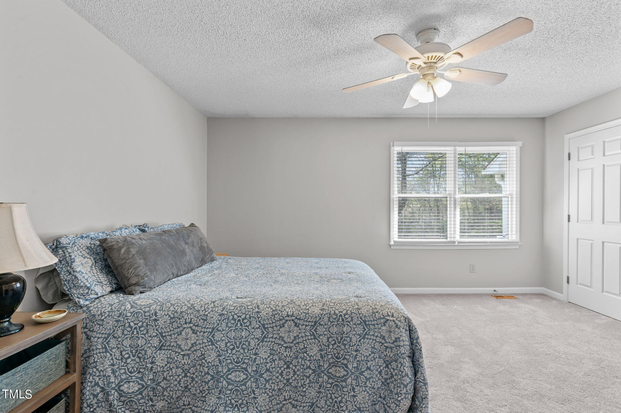 6908 Saxby Court Raleigh, NC 27613 - Photo 23 of 27 a bedroom with a bed a chandelier and a window