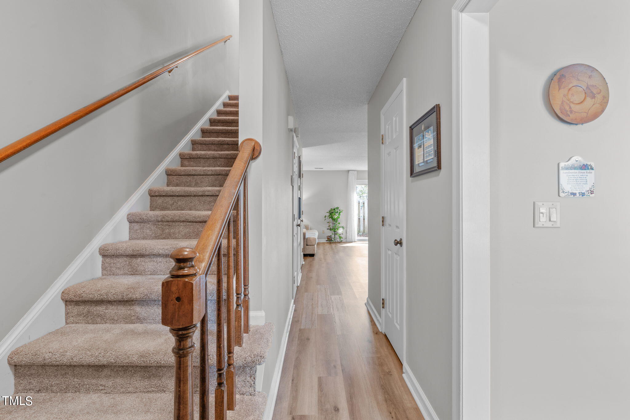 6908 Saxby Court Raleigh, NC 27613 - Photo 4 of 27 a view of a hallway with wooden floor and staircase