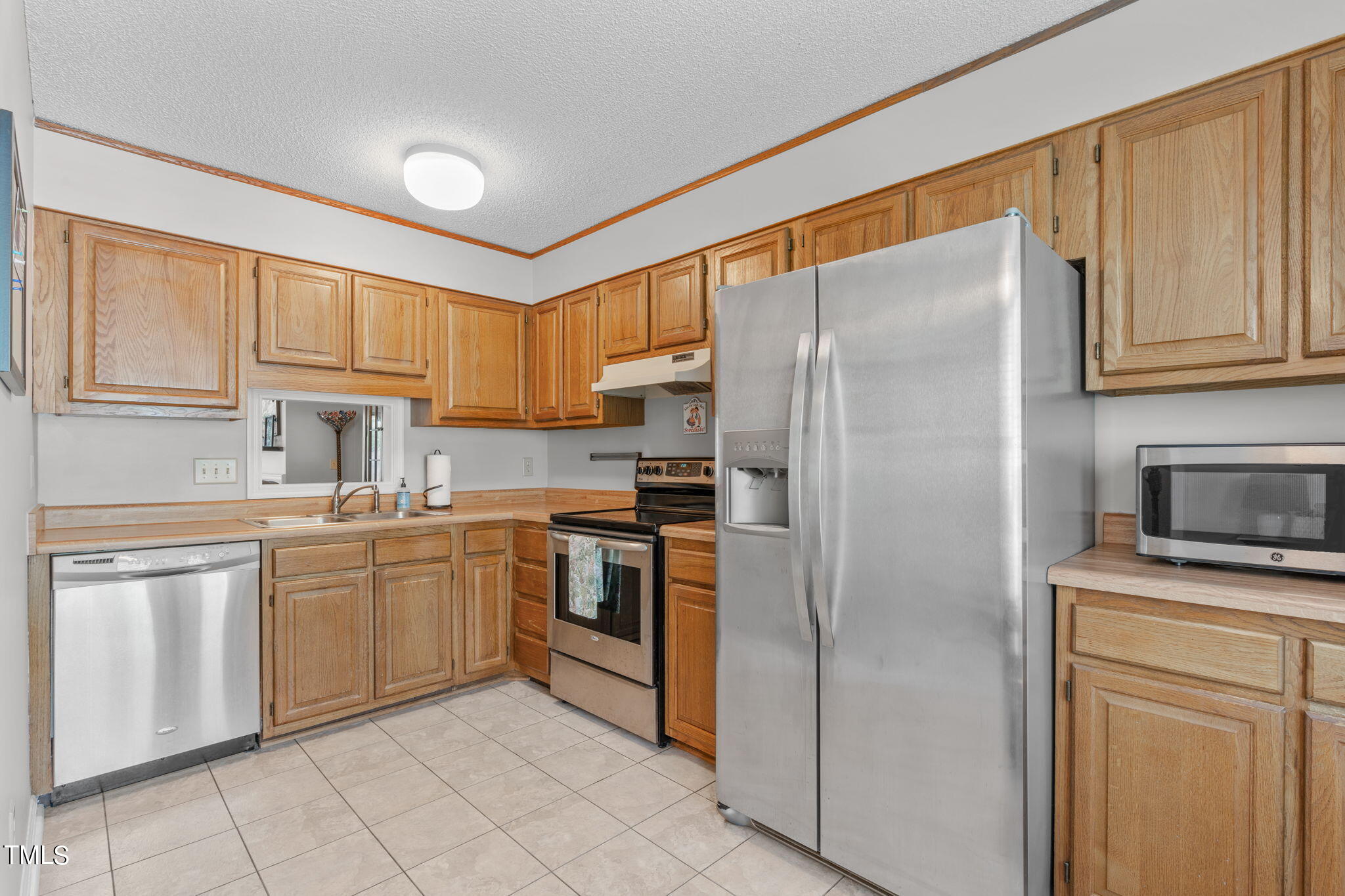 6908 Saxby Court Raleigh, NC 27613 - Photo 6 of 27 a kitchen with stainless steel appliances granite countertop a refrigerator sink and cabinets