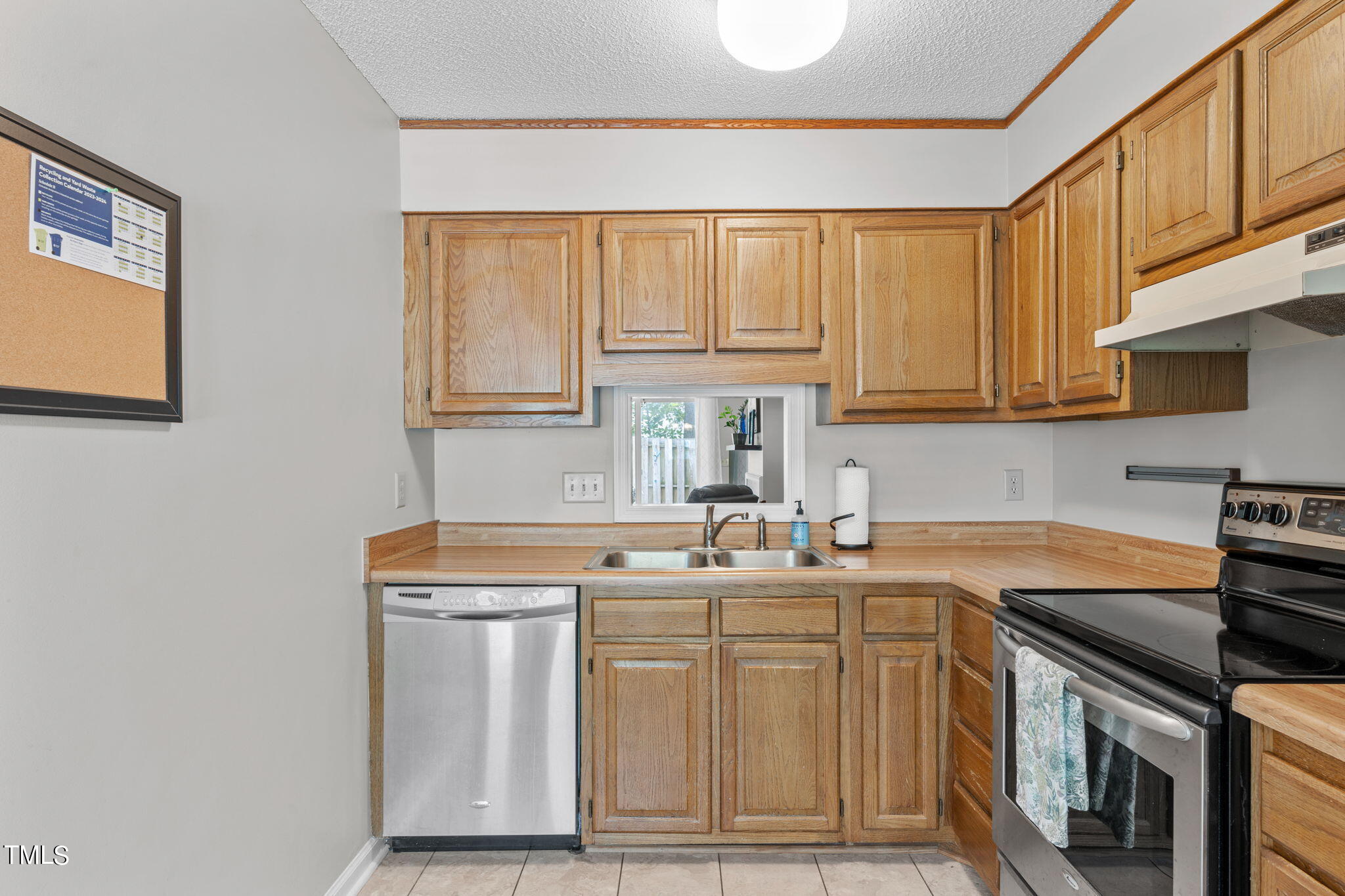 6908 Saxby Court Raleigh, NC 27613 - Photo 7 of 27 a kitchen with stainless steel appliances granite countertop a sink stove and cabinets