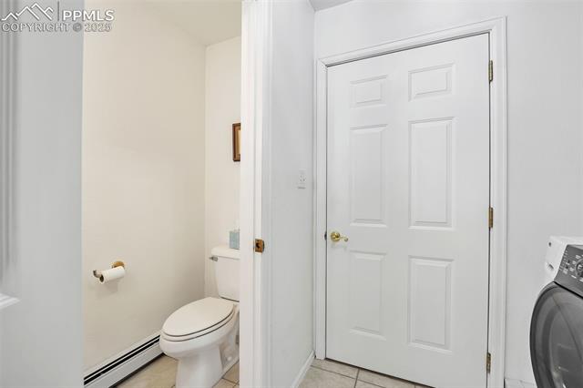 3954 County Rd KK 75 Fowler, CO 81039 - Photo 17 of 41 Bathroom with tile patterned floors, baseboard heating, toilet, and washer / clothes dryer