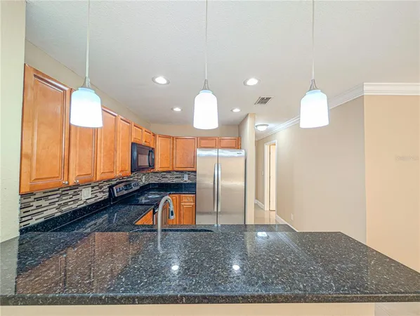 a kitchen with stainless steel appliances granite countertop a stove and a microwave