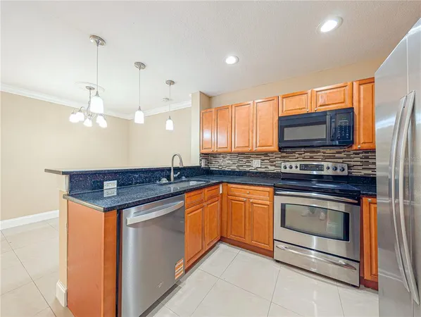 a kitchen with stainless steel appliances granite countertop a refrigerator and a stove