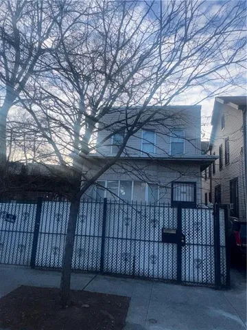 a view of backyard with large trees and wooden fence