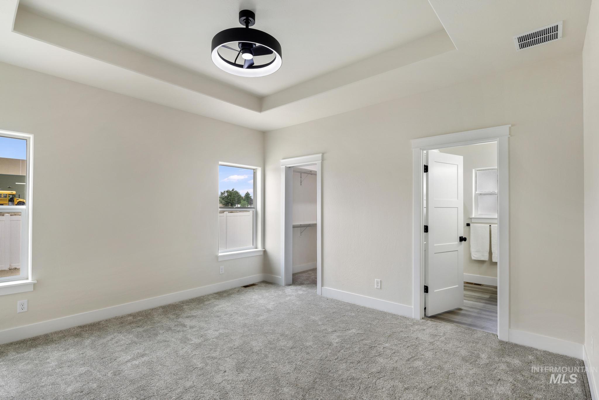 928 Gregory Way Twin Falls, ID 83301 - Photo 12 of 24 Unfurnished bedroom featuring a raised ceiling, carpet, and a walk in closet