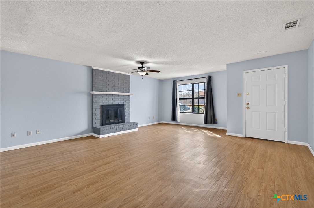 3421 Chisholm Trail Killeen, TX 76542 - Photo 7 of 34 a view of an empty room with wooden floor fireplace and a window
