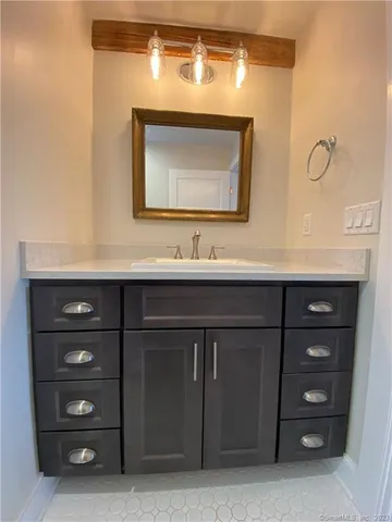 a bathroom with a sink vanity and a mirror