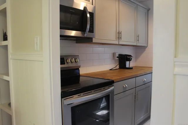 a kitchen with granite countertop a stove and a microwave