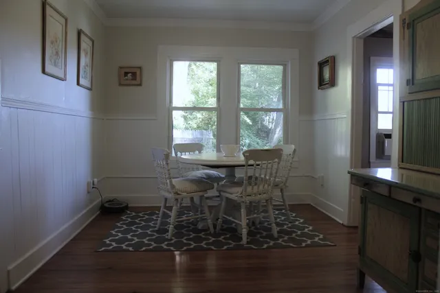 a dining room with wooden floor and a window