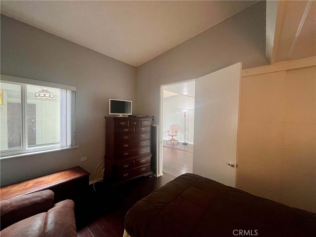 1842 Thunderbird Drive, Unit 1C Seal Beach, CA 90740 - Photo 11 of 16 a bedroom with a bed and wooden floor