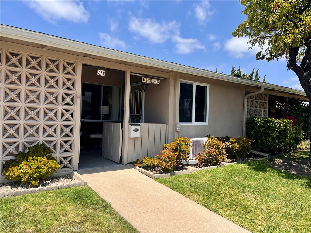 1842 Thunderbird Drive, Unit 1C Seal Beach, CA 90740 - Photo 3 of 16 a front view of a house with a yard