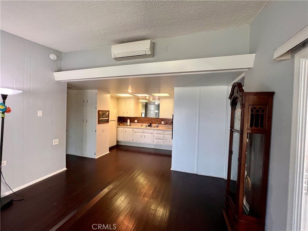1842 Thunderbird Drive, Unit 1C Seal Beach, CA 90740 - Photo 8 of 16 a view of a hallway to an empty room with wooden floor and a kitchen