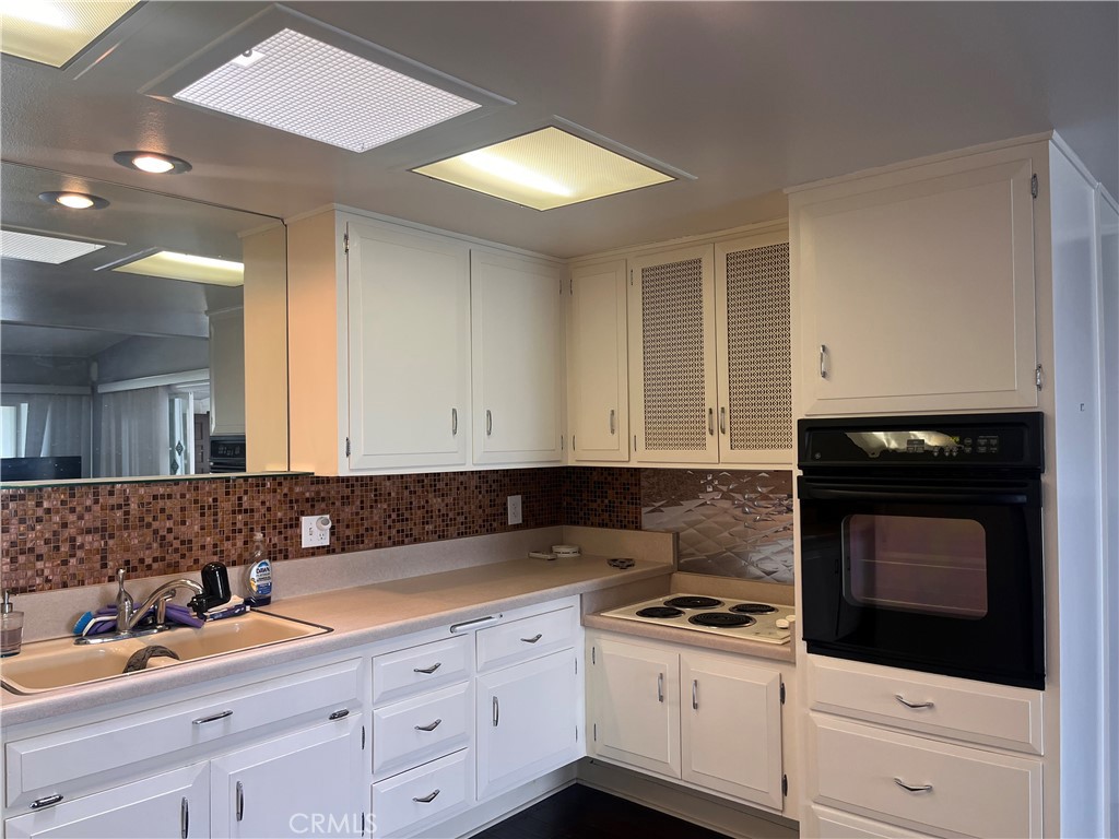 1842 Thunderbird Drive, Unit 1C Seal Beach, CA 90740 - Photo 10 of 16 a kitchen with granite countertop a sink a stove and cabinets