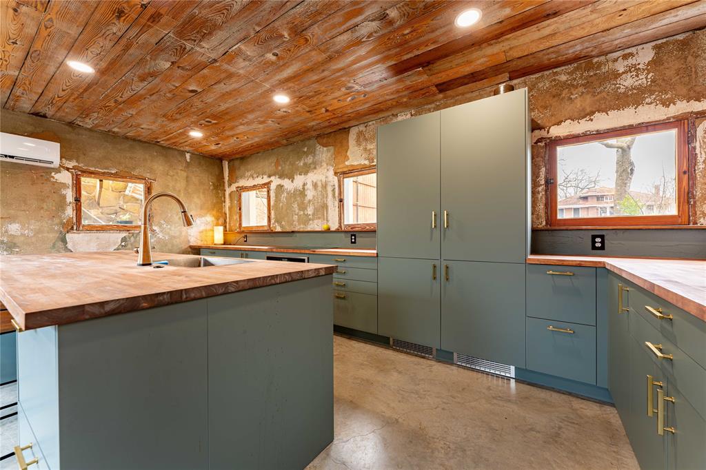 621 South Main Street Paris, TX 75460 - Photo 19 of 30 Kitchen with concrete floors, wood counters, wooden ceiling, a wall mounted AC, and a sink