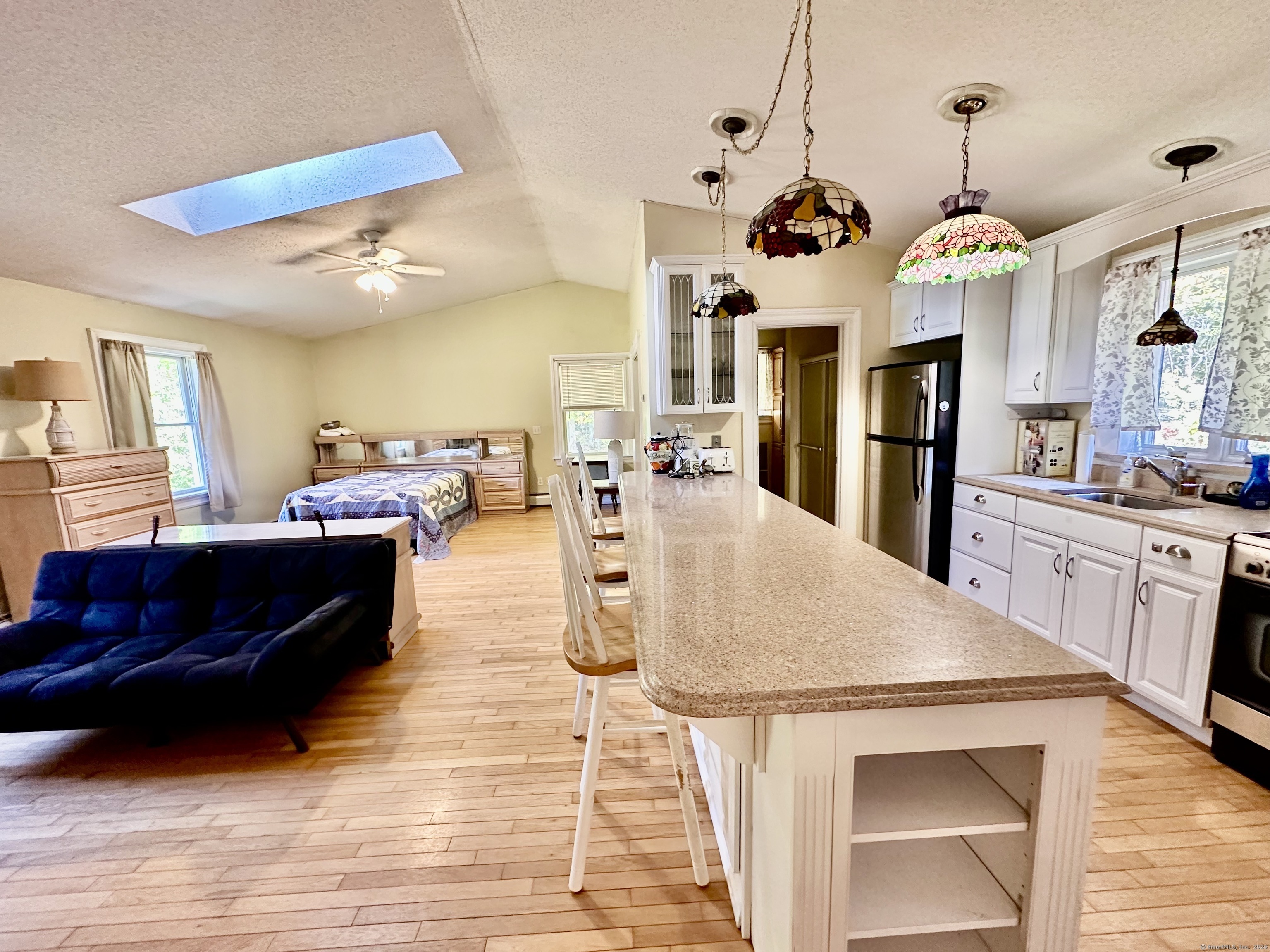 288 Leonard Bridge Road Lebanon, CT 06249 - Photo 13 of 14 a living room with kitchen island furniture and a chandelier