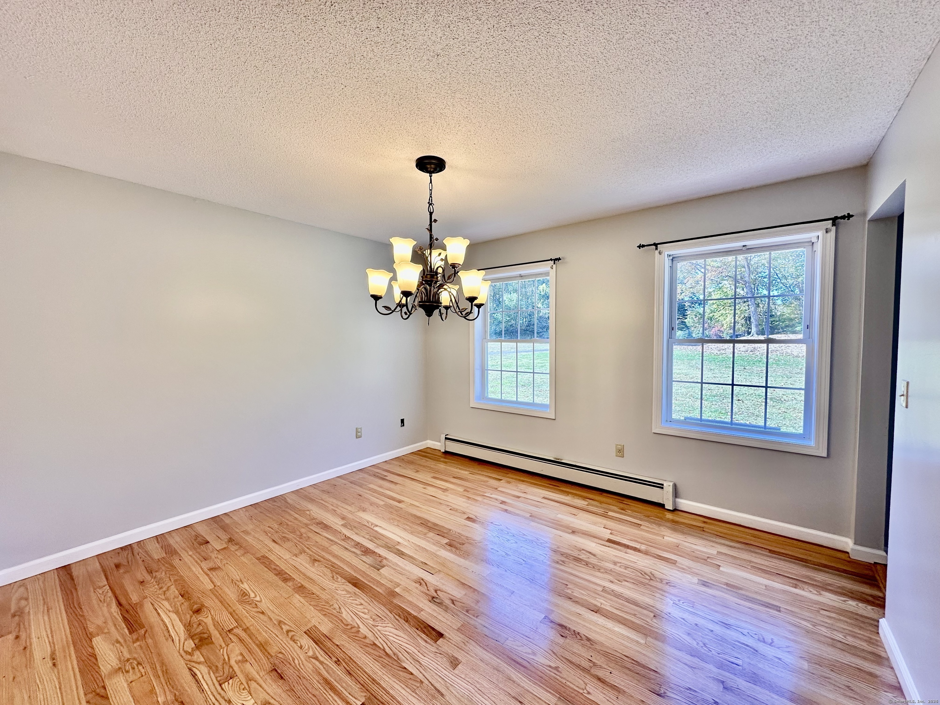 288 Leonard Bridge Road Lebanon, CT 06249 - Photo 8 of 14 an empty room with wooden floor and windows