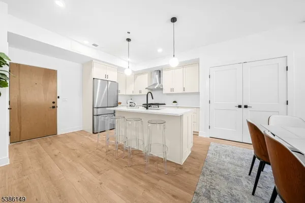 a kitchen with a sink a refrigerator and white cabinets
