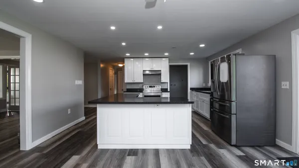 a kitchen with stainless steel appliances granite countertop a refrigerator and a sink