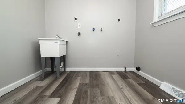 a view of a room with wooden floor and a sink