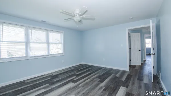 a view of a room with wooden floor and a window