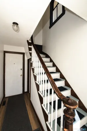 a view of staircase with lots of frames on wall and a window