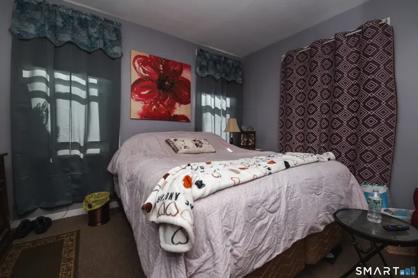a bedroom with a bed and a painting on the wall