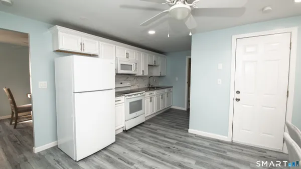 a kitchen with white cabinets and white appliances