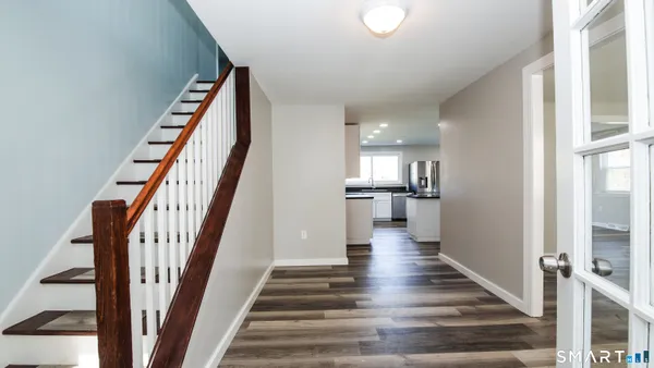 a view of entryway and hall with wooden floor