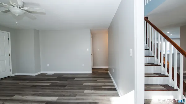 a view of a hallway with wooden floor and staircase