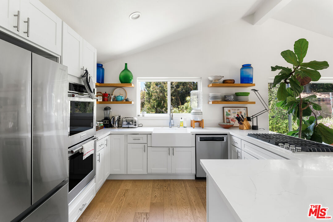 6551 Zumirez Drive Malibu, CA 90265 - Photo 16 of 36 a kitchen with a refrigerator and a white cabinets