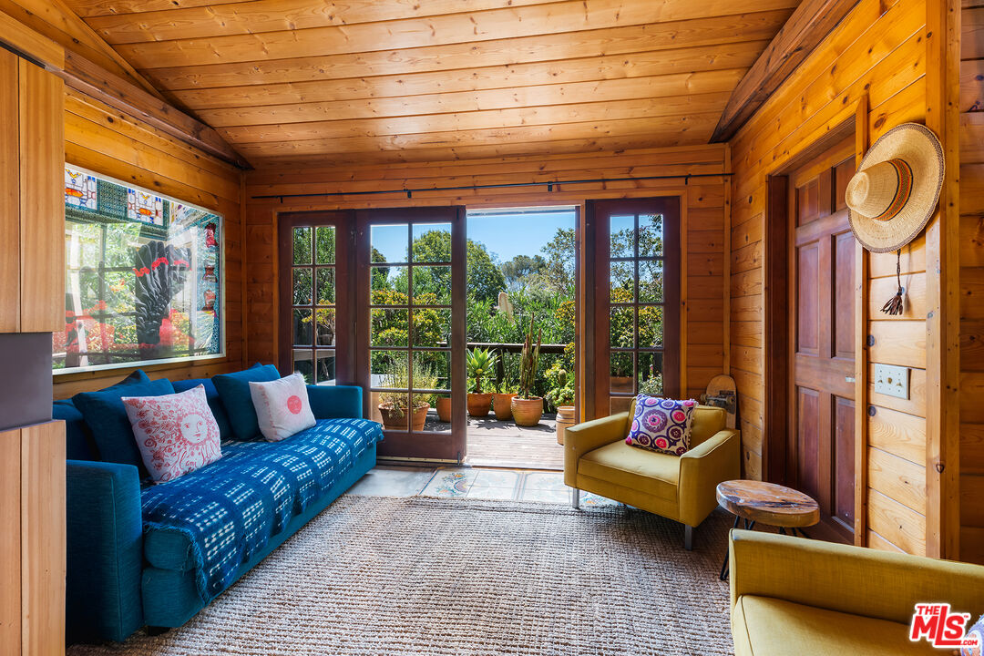 6551 Zumirez Drive Malibu, CA 90265 - Photo 26 of 36 a living room with furniture and a floor to ceiling window