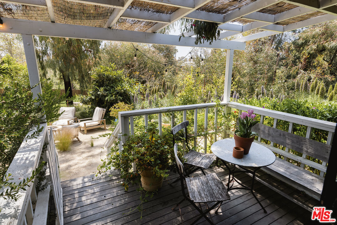6551 Zumirez Drive Malibu, CA 90265 - Photo 29 of 36 a balcony with wooden floor and outdoor seating