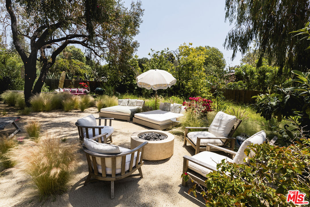 6551 Zumirez Drive Malibu, CA 90265 - Photo 32 of 36 a view of a patio with couches table and chairs and potted plants
