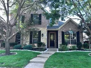 front view of a house with a yard and an trees