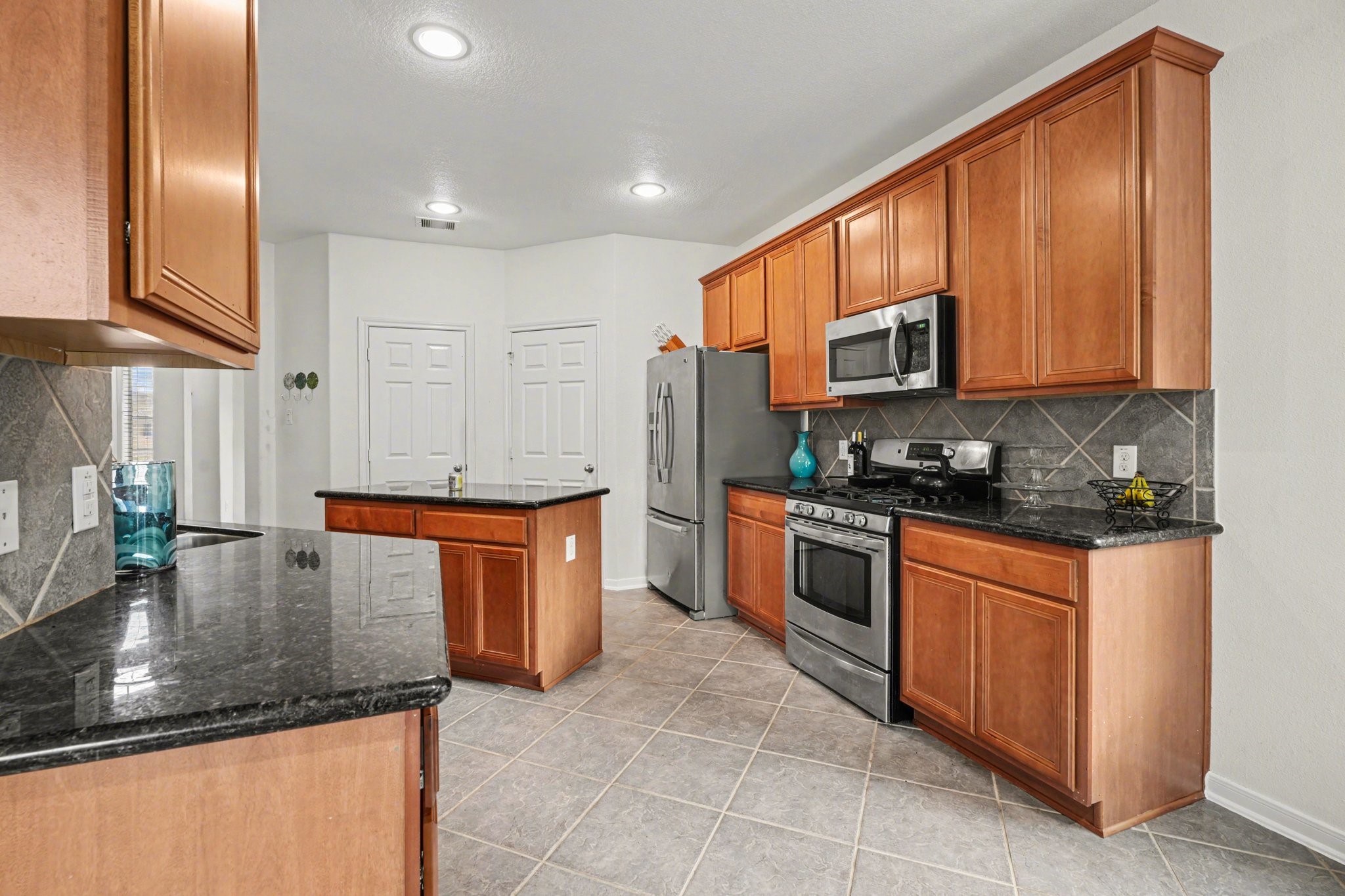 806 Dawn Ridge Way Seabrook, TX 77586 - Photo 11 of 39 a kitchen with stainless steel appliances granite countertop a stove a sink and a microwave