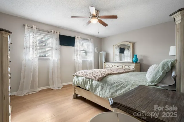 a bedroom with a bed a window and a chandelier