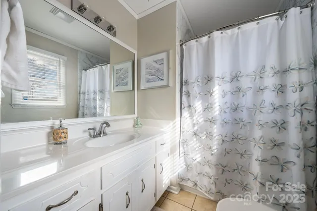 a bathroom with a granite countertop sink a mirror and shower