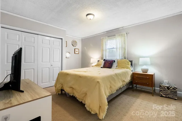 a bedroom with a bed flat screen tv and dresser
