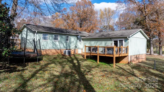 a view of a house with a backyard and wooden deck