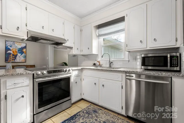 a kitchen with stainless steel appliances granite countertop a stove and a microwave