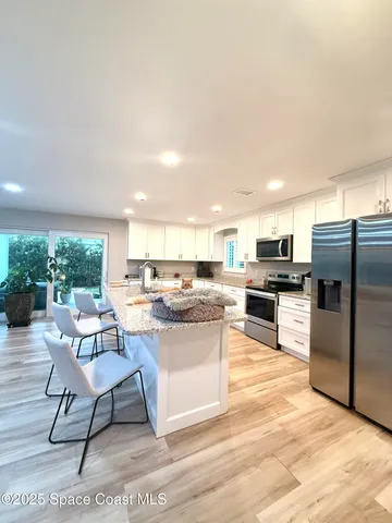 a view of a house with a swimming pool and sitting area