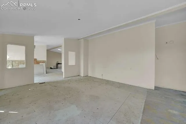 a view of an empty room with windows and chandelier