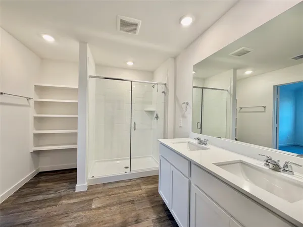 a bathroom with a double vanity sink mirror and shower