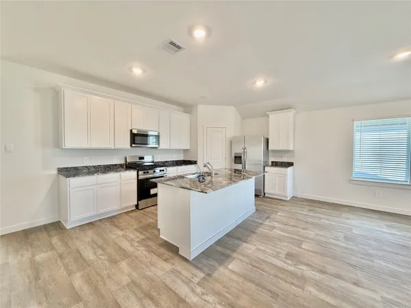 a kitchen with white cabinets and white appliances