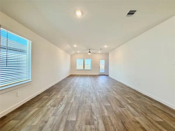wooden floor in an empty room with a window